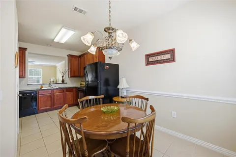 a dining room with wooden floor a chandelier a wooden table and chairs