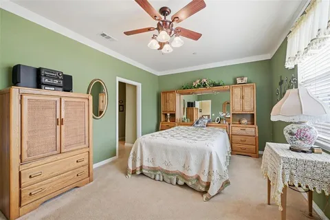 a bedroom with a bed a dresser and potted plants