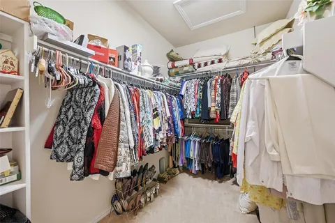 a view of walk in closet with clothes
