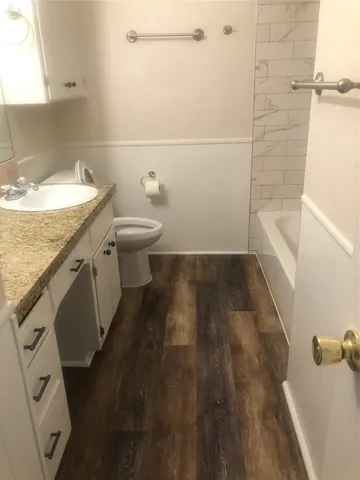 a bathroom with a granite countertop sink toilet and shower