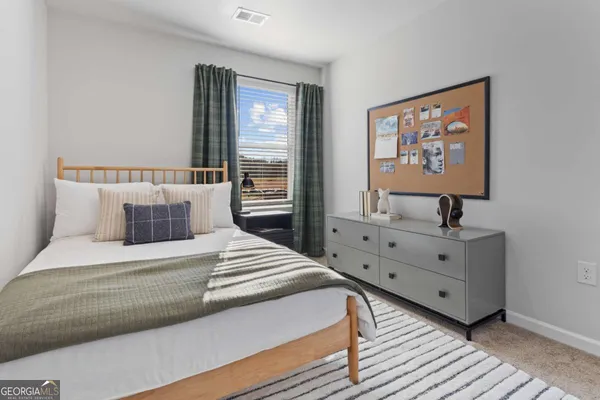 a spacious bedroom with a bed and a large window