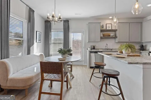 a kitchen with a dining table chairs and white cabinets