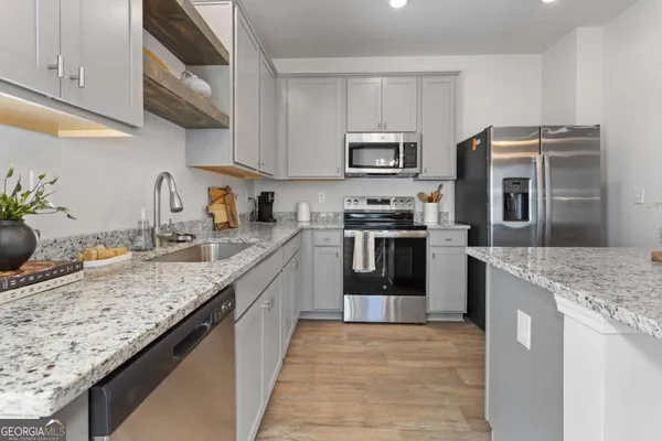 a kitchen with stainless steel appliances granite countertop a sink stove and refrigerator