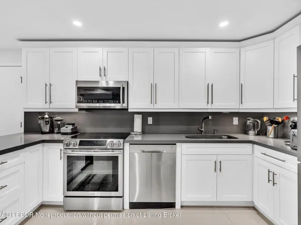 a kitchen with cabinets stainless steel appliances and a sink