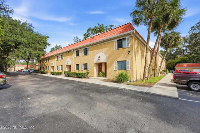 a view of a house with a yard and parking space