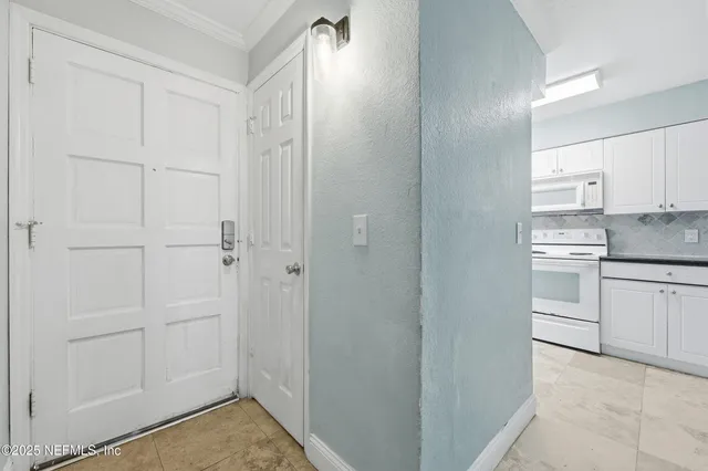 a view of a hallway with stainless steel appliances
