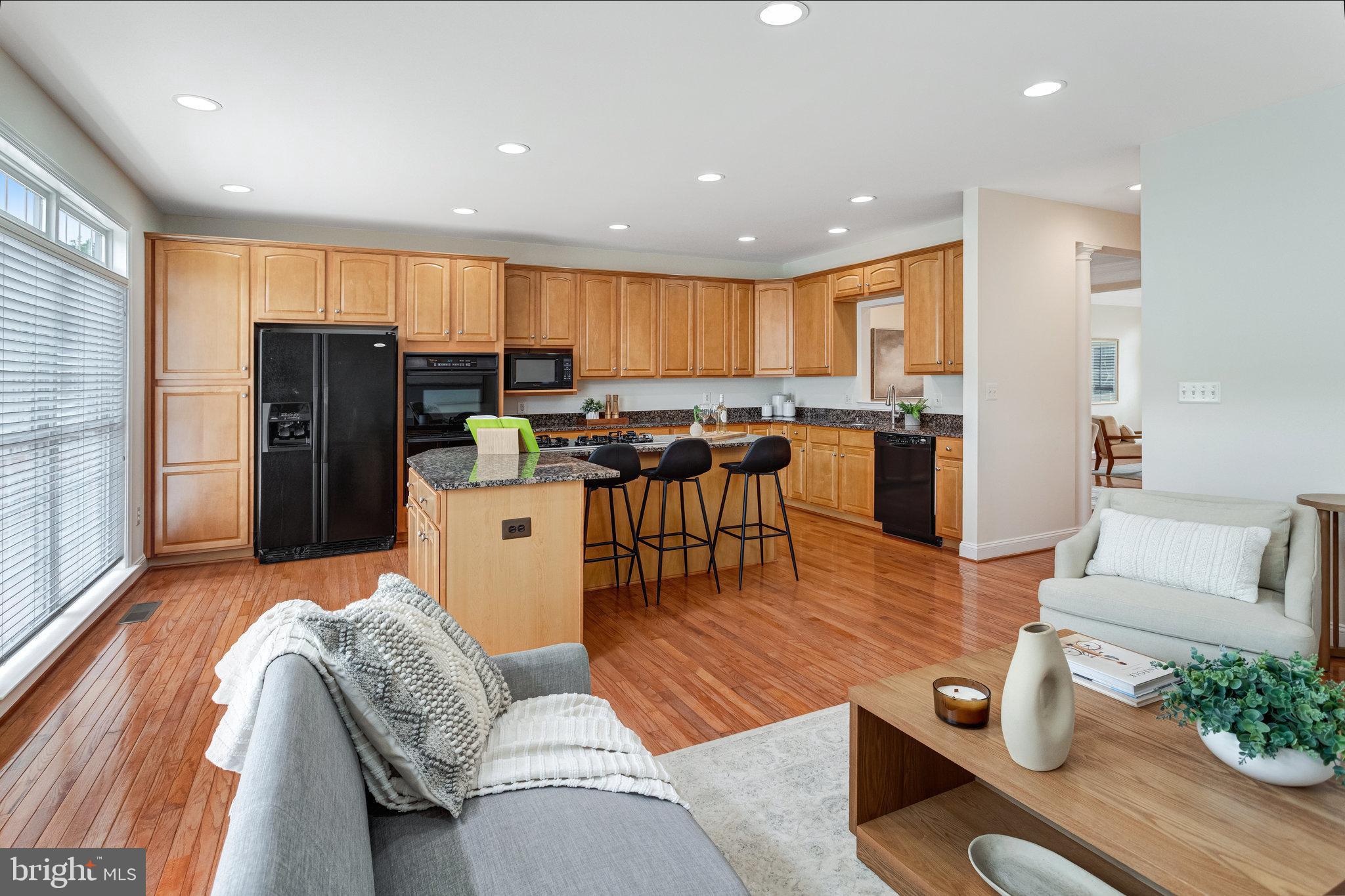 25804 Commons Square Chantilly, VA 20152 - Photo 11 of 48 a living room with stainless steel appliances furniture wooden floor and a kitchen view