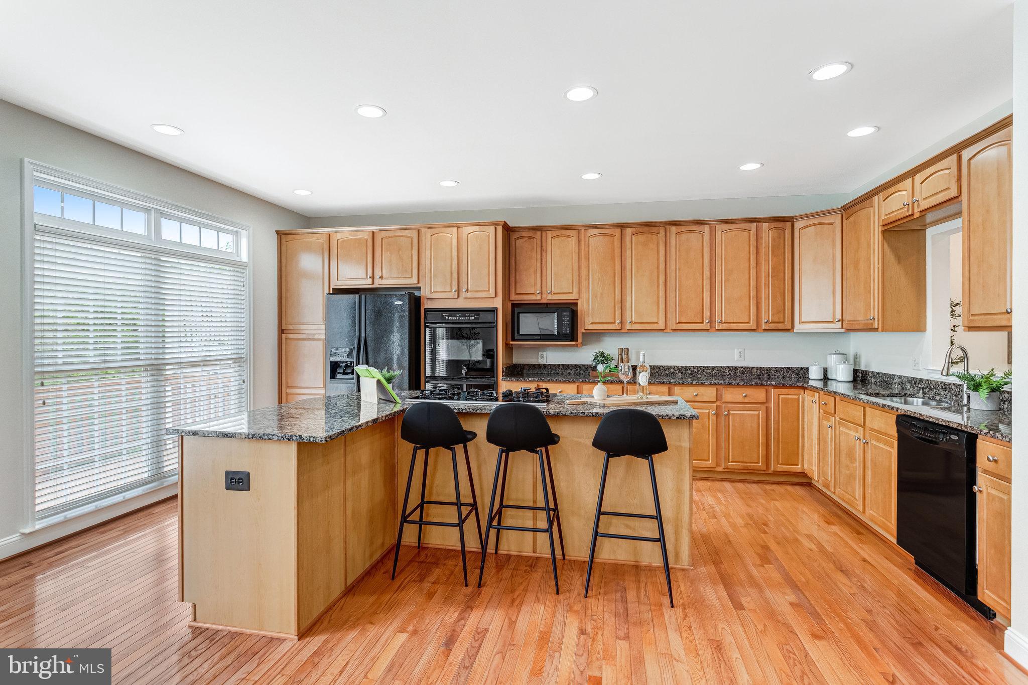 25804 Commons Square Chantilly, VA 20152 - Photo 13 of 48 a kitchen with stainless steel appliances a stove a sink a refrigerator and cabinets with wooden floor