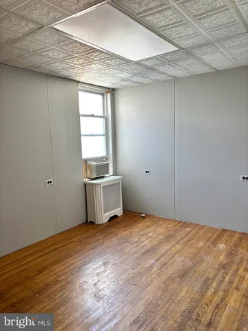 a view of a room with wooden floor and white walls