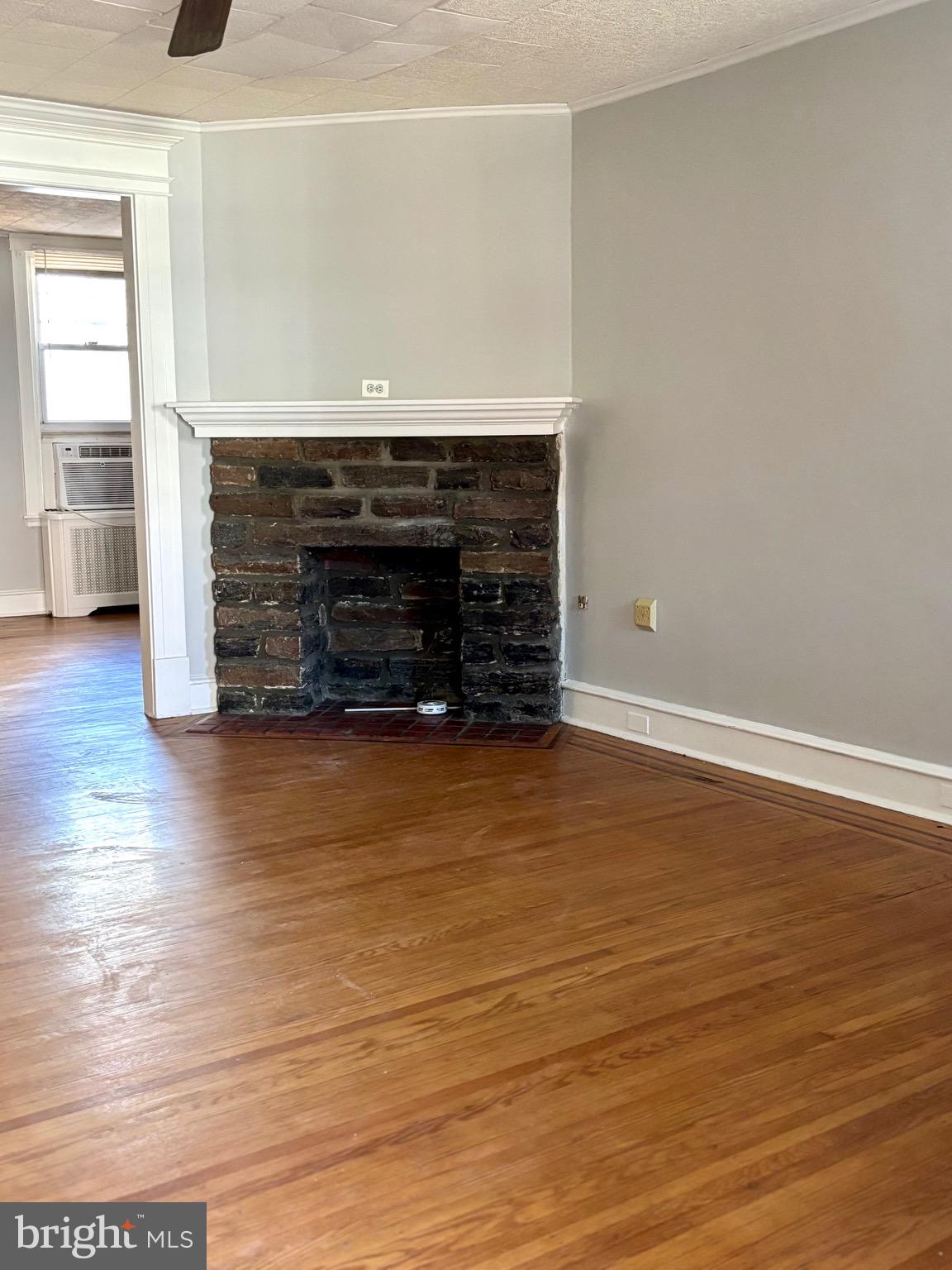 7242 Brent Road Upper Darby, PA 19082 - Photo 5 of 14 an empty room with wooden floor fire place and window