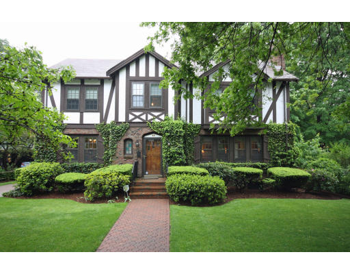 a view of a brick house with a yard and plants