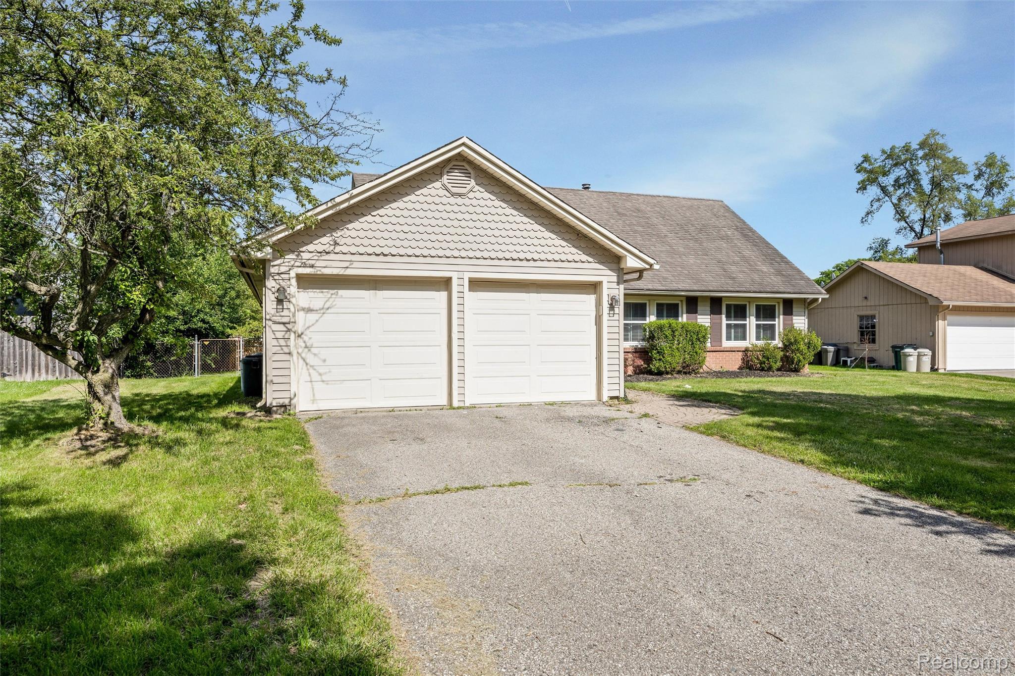 4942 Butler Drive Troy, MI 48085 - Photo 3 of 33 Property exterior featuring a two-car garage with overhead doors, shingle-style siding, and a gabled roofline