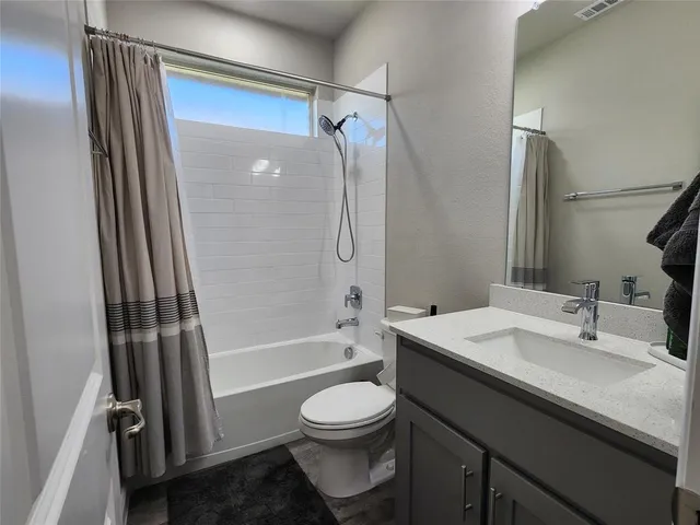 a bathroom with a granite countertop sink toilet a shower and a mirror