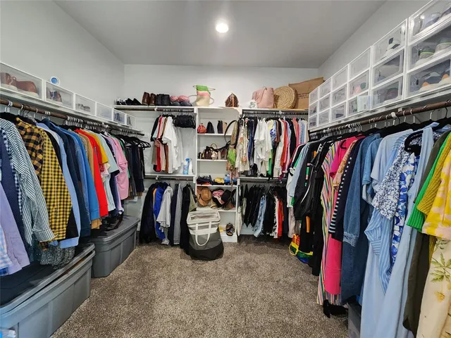 a view of walk in closet with clothes