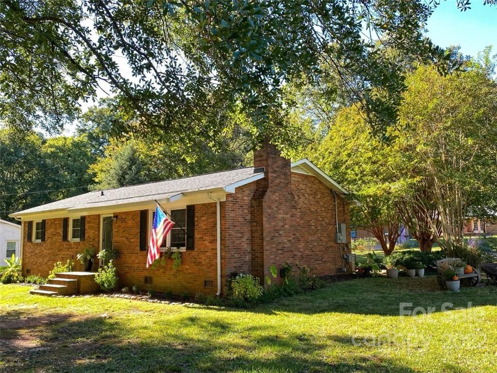 a view of a house with yard next to a big yard