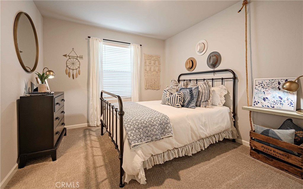 64 River Oak Court, Unit 47 SE Merced, CA 95341 - Photo 13 of 18 a bedroom with a bed and dresser with mirror