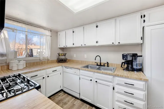 a kitchen with white cabinets and appliances
