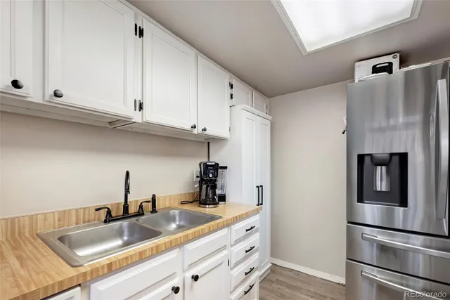 a kitchen with granite countertop a refrigerator and a sink