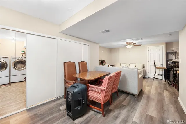 a living room with furniture a dining table and chairs with wooden floor