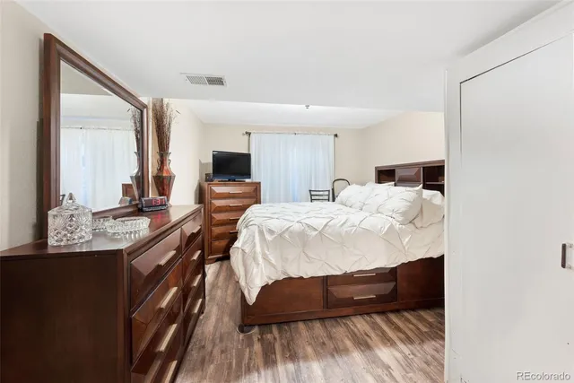 a bedroom with a bed a mirror and dresser