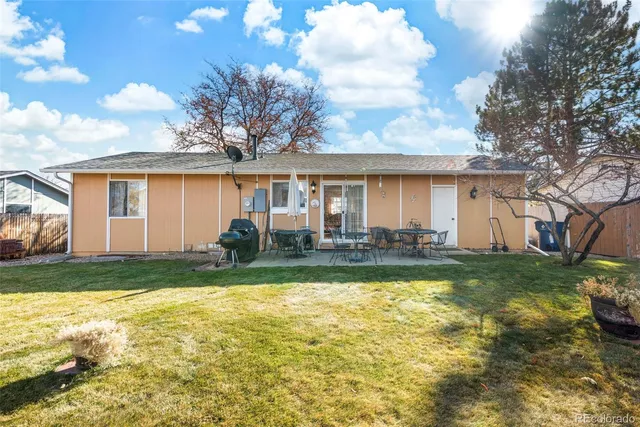 a view of a house with backyard and sitting area
