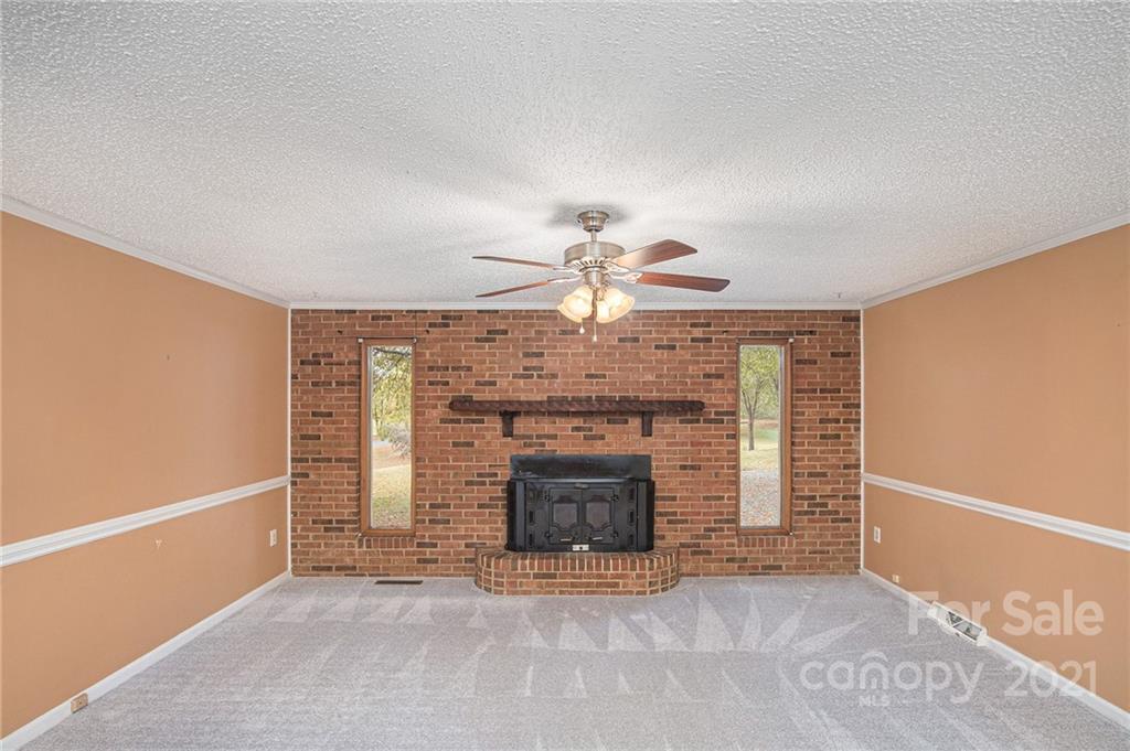 1655 Songwood Road Concord, NC 28025 - Photo 3 of 21 an empty room with fireplace and fan