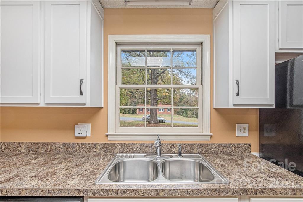 1655 Songwood Road Concord, NC 28025 - Photo 8 of 21 a kitchen with granite countertop a sink window and cabinets
