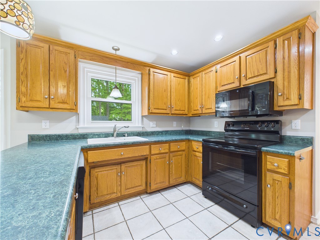 4502 Greyfield Place Chester, VA 23831 - Photo 21 of 40 a kitchen with stainless steel appliances granite countertop a stove a sink and a microwave