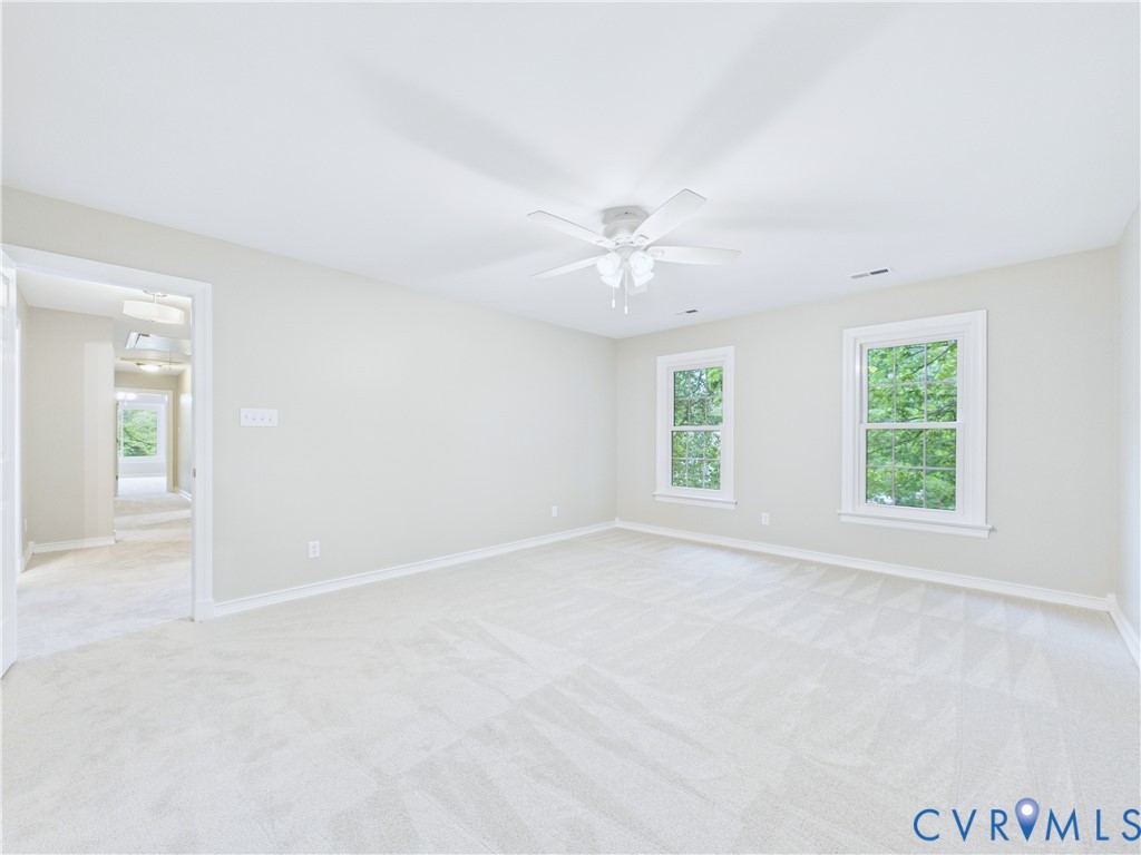 4502 Greyfield Place Chester, VA 23831 - Photo 32 of 40 an empty room with windows and chandelier fan