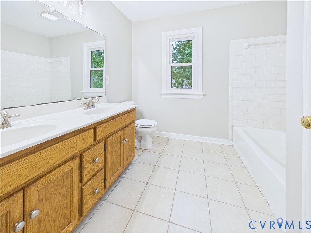 4502 Greyfield Place Chester, VA 23831 - Photo 38 of 40 a bathroom with a granite countertop sink a toilet and a window