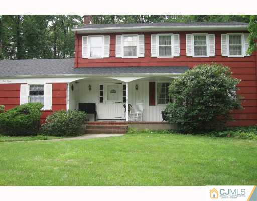 a front view of a house with a yard and trees