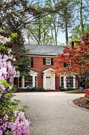 a front view of a house with a tree