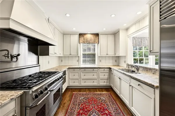 a kitchen with stainless steel appliances granite countertop a sink and a white cabinets