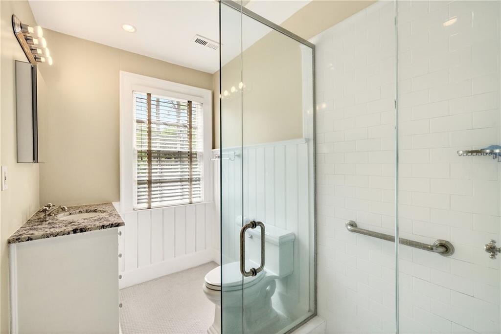596 West Wesley Road Northwest Atlanta, GA 30305 - Photo 40 of 60 a bathroom with a granite countertop sink a mirror and a shower