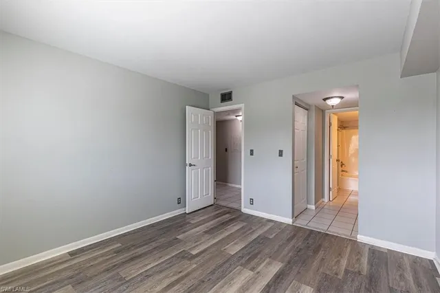 an empty room with wooden floor and window