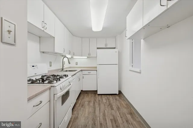 a kitchen that has a lot of cabinets a sink and a stove in it