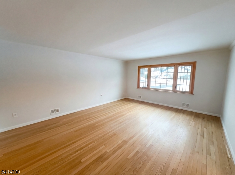 78 Parkside Road Plainfield, NJ 07060 - Photo 3 of 29 an empty room with wooden floor and windows