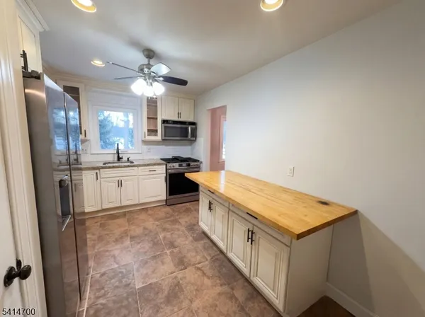a kitchen with kitchen island a sink stainless steel appliances and cabinets