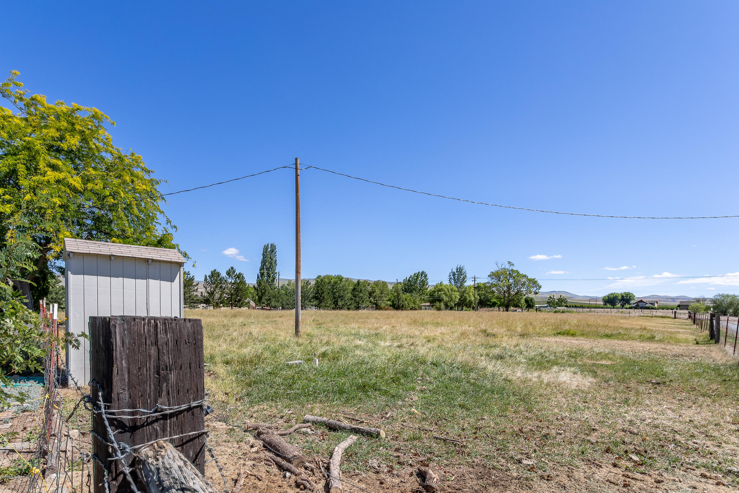 1020 Beane Road Moxee, WA 98936 - Photo 14 of 36 a view of a backyard with barn plants and large trees
