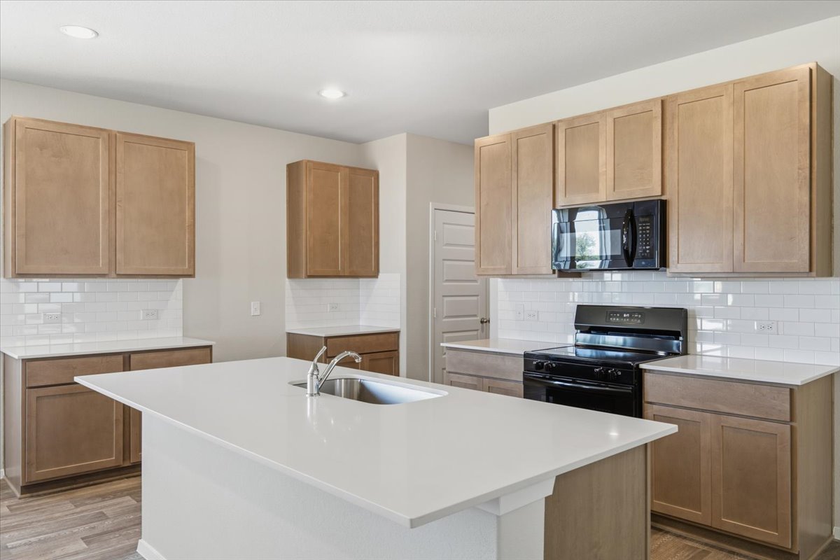 2714 Foss Road Manor, TX 78653 - Photo 11 of 34 Clean lines and a spacious center island define this modern kitchen layout.