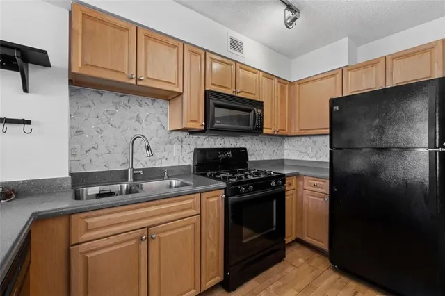 a kitchen with granite countertop a refrigerator stove and microwave