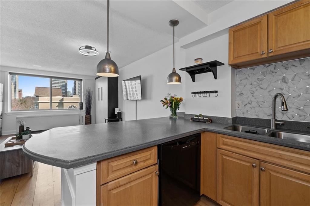 2479 Peachtree Street Northeast, Unit 912 Atlanta, GA 30305 - Photo 14 of 36 a kitchen with granite countertop a sink a counter space appliances and cabinets