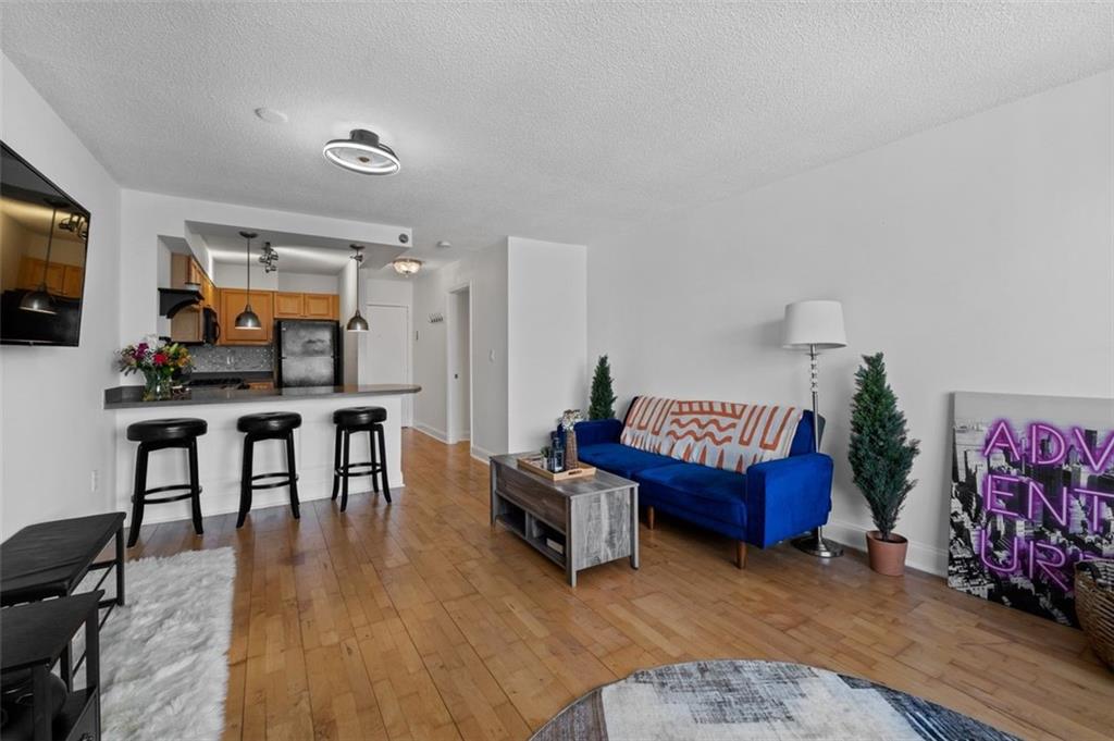 2479 Peachtree Street Northeast, Unit 912 Atlanta, GA 30305 - Photo 16 of 36 a living room with furniture a flat screen tv and a wooden floor