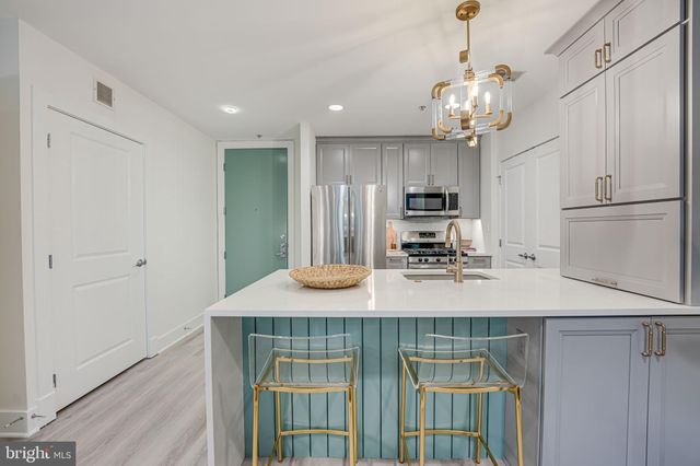 a kitchen with kitchen island stainless steel appliances sink cabinets and stove