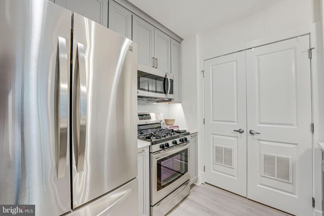 a kitchen with white cabinets and white appliances