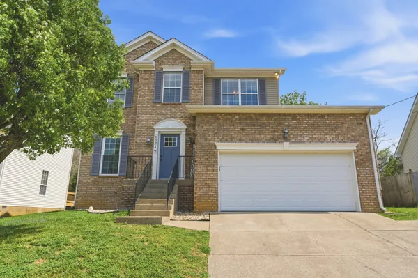 a front view of a house with a yard and garage