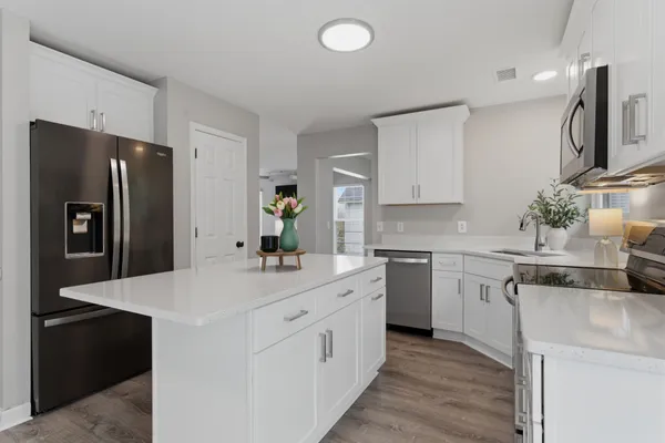 a kitchen with white cabinets and stainless steel appliances