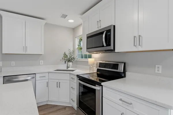 a kitchen with white cabinets stainless steel appliances and sink