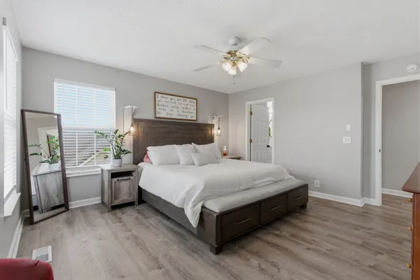 a spacious bedroom with a large bed and a chandelier