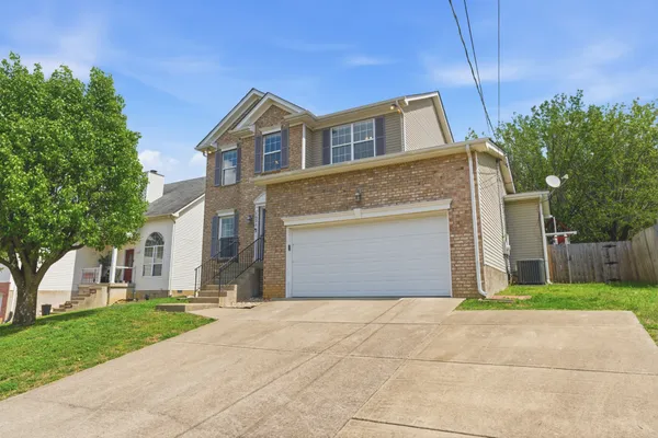 a front view of a house with a yard and garage